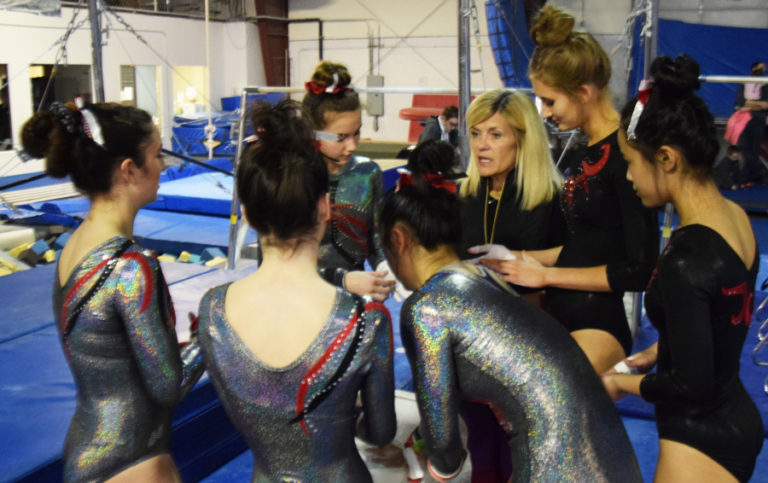 Camas High School gymnastics coach Carol Willson chats with the gymnasts warming up to compete in bars during a meet at Northpointe on Friday, Jan.