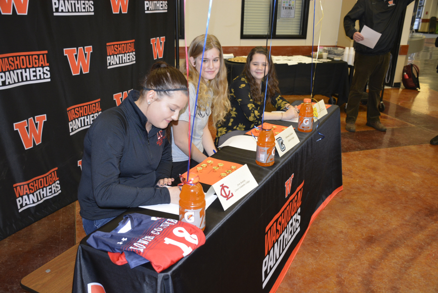LEFT: Erin Bentley, Lower Columbia College; Sierra Coloma, Northwest Christian University; and Hannah Eakins, Clark College sign letters of intent at Washougal High School on Wednesday.