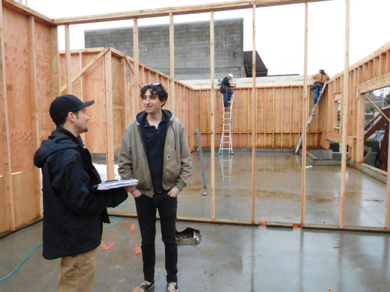 Chad Holsinger, a general contractor with A Team Construction LLC (left), and Westin Glass, a project manager with Guerrilla Development Co. (right), communicate Feb. 2, about the mixed-use development under construction by crews from A Team at 1911 Main St., in downtown Washougal.
