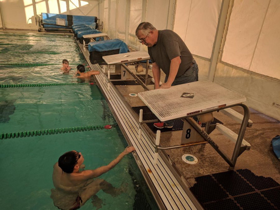 Camas-Washougal boys swimming coach Mike Bemis (right) talks strategy with state champion swimmer Mark Kim on Monday, Feb. 12. (Wayne Havrelly/Post-Record)