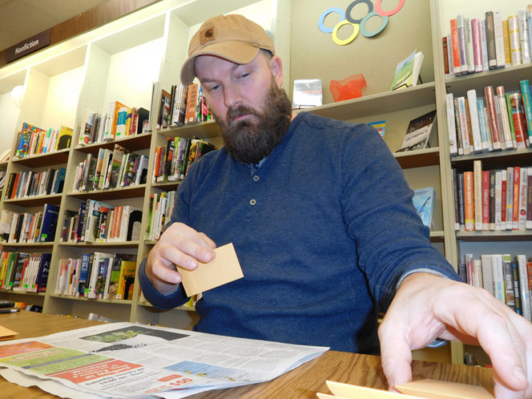 David Gano, a Camas native who lives in Hockinson, puts seeds into envelopes to be checked out at the Washougal Community Library.