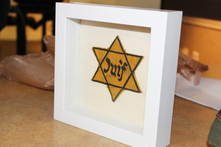 The actual yellow Star of David worn by Matthew Erlich&#039;s aunt, Lola, who lived in Paris during World War II. Nazis forced all Jewish people living in Nazi-occupied Europe to wear the yellow star as a form of identification during the war. This star reads &quot;juif,&quot; the French word for Jewish.