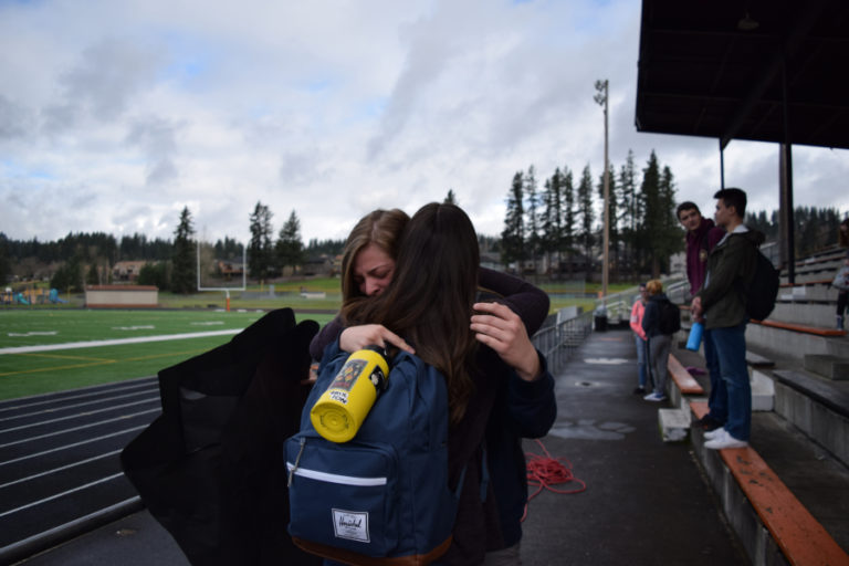 Washougal senior Emilee Smart hugs one of the Washogual High student organizers of the walkout after a reading of the names of 17 Parkland, Florida, school shooting victims. Smart said she began to get emotional when hearing all the names of the victims and the people who died trying to shield others in the Feb. 14 shooting, because it could easily have been one of her friends or teachers.