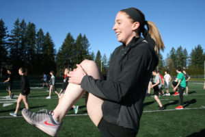 State champion high jumper Madison Peffers stretches out during one of the first practice sessions of the season. Peffers says she's excited about working with the new coaching staff. 