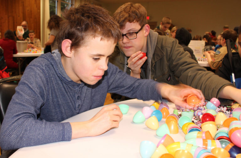 Fenix Roark, 14 (left), and Tristan Freckleton, 16, students from the Vancouver-based Washington State School for the Blind, help fill eggs for the city of Camas&#039; annual Easter Day Egg Hunt on March 26.