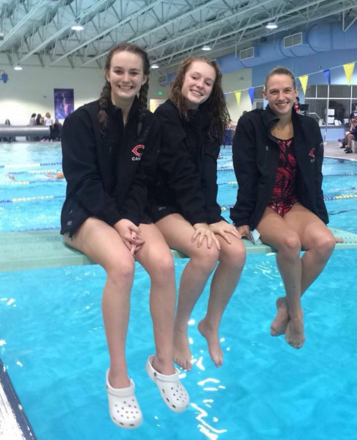 Camas divers, from left to right, Shea McGee, Lyn McGee and Jacqueline Purwins gather at a meet last fall at Bainbridge Island, Wash.