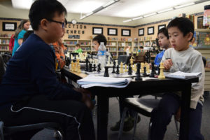Camas chess players from left to right, Yu-Cheng Liang,  Alexander Yu, Derek Heath and Eric Zhang compete in a five-round game of Swiss during the YMCA Chess Tournament on Saturday, March 31, at Orchards Elementary School, in Vancouver. The YMCA tournament was the last competition where players were able to qualify for the state championships, which will be held on Saturday, April 21, in Pasco Washington. Nine Camas students are headed to the state competition. (Tori Benavente/Post-Record)