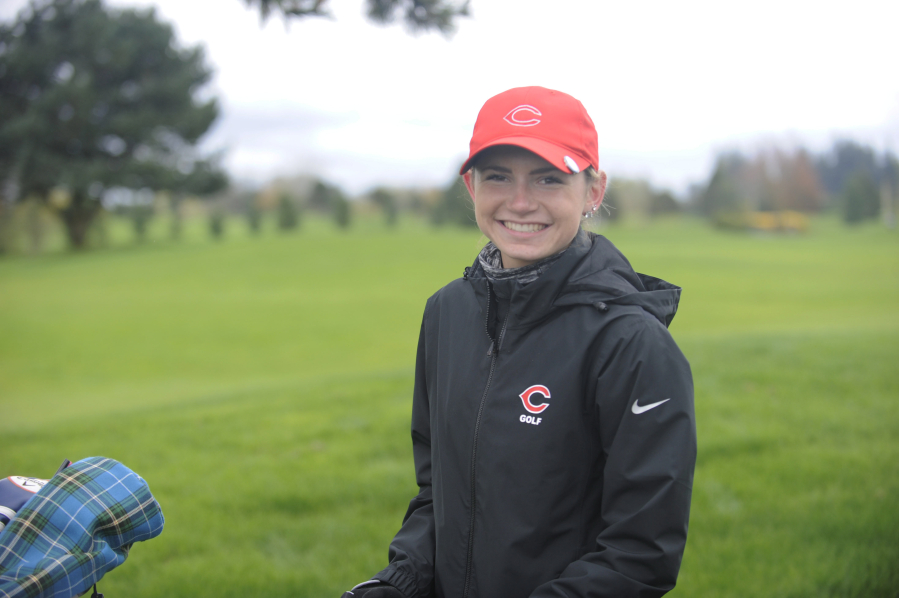 Camas senior Hailey Oster keeps a smile on her face despite the wet, blustery day at the Titan Cup at Tri-Mountain Golf Colf Course in Ridgfield on Monday, April 16.