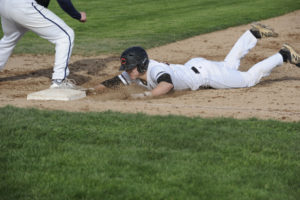Camas all-league catcher Grant Heiser safely slides into first base while aggressively running the bases against Skyview on Wednesday, April 18.