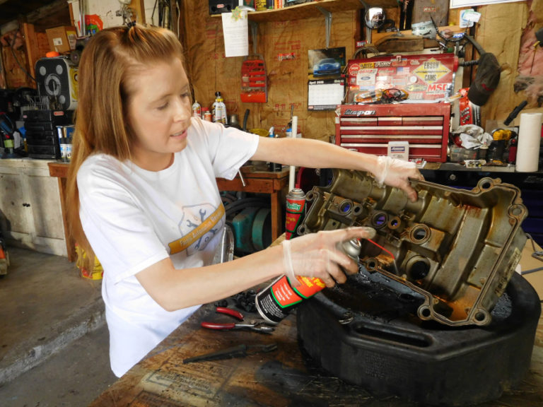Heather Farris, office manager of Farris Automotive Repair, in Washougal, cleans a valve cover.