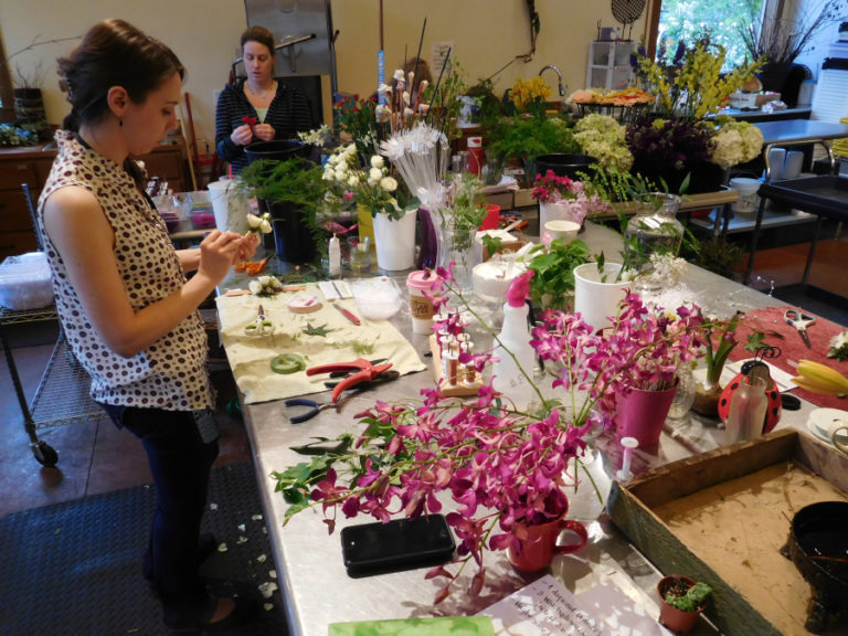 Annette Cohen, a designer at Flowers Washougal, and co-workers Bethany Beigh and Kate Northcut (from left to right) make corsages April 27, for the Washougal High School prom scheduled for the following night. Beigh said she would like to see an ice cream shop, a family style restaurant and a business that showcases local artists, open on &quot;E&quot; Street.
