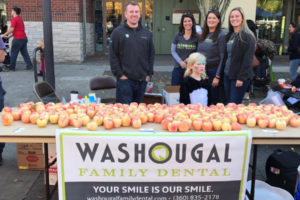 Dr. Justin Cochell and the rest of the Washougal Family Dental team hand out apples and toys to children during the Downtown Washougal Pumpkin Harvest Festival on Oct. 28, 2017. (Photo contributed by Washougal Family Dental)