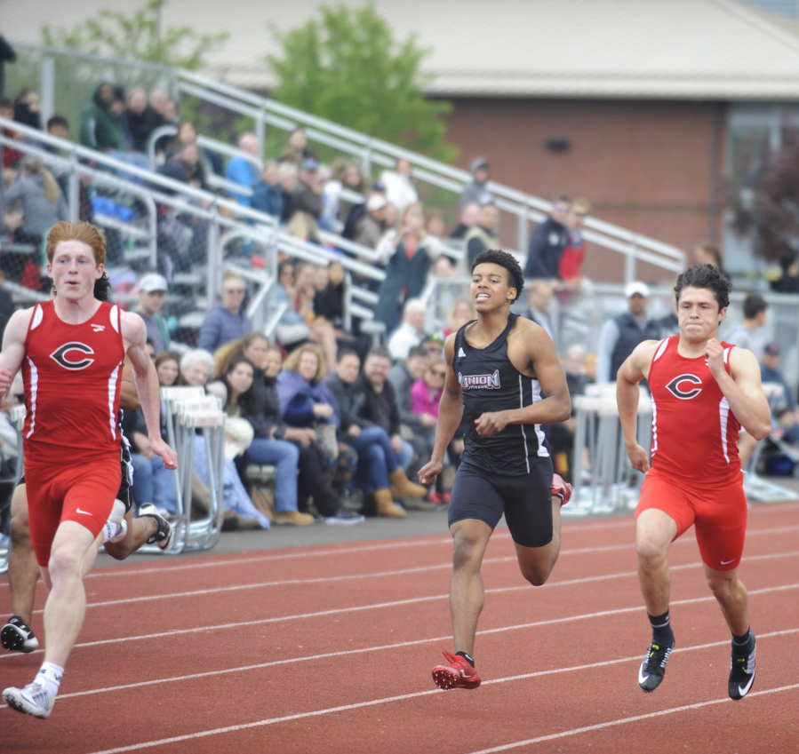 Camas sprinter Blake Deringer (left) hits full stride, winning the 100-meter race against Union on Friday, May 4.