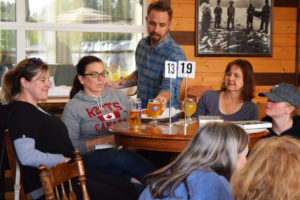 Members of the Books and Brews Book Club celebrate the arrival of chicken strips and french fries at their 54?40' Brewing Company table during the June 4 book club meeting.