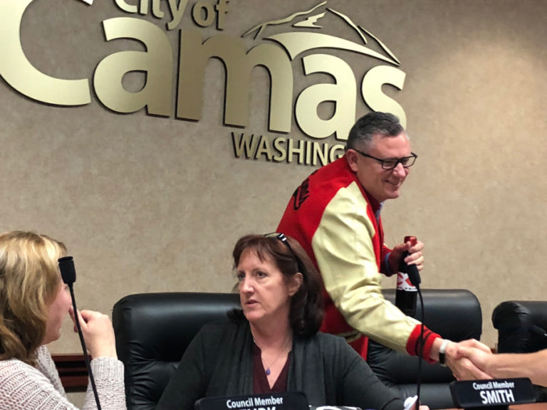 Camas Mayor Scott Higgins (right), wearing his Camas High letterman&#039;s jacket and holding his trademark Camas Papermakers water bottle, shakes hands with well-wishers after the Monday, June 11 city council work session, in which he announced his unexpected resignation, effective Sept. 30. Also pictured: Camas City Council members Shannon Turk (left) and Melissa Smith (center).