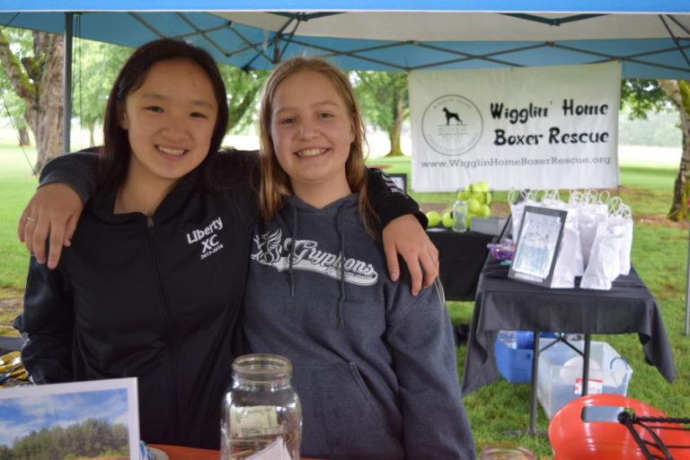 Odyssey Middle School students Grace Duffey (left) and Aleah Anderson (right) during a fundraiser event that the 13-year-old girls organized as a part of their &quot;What Would You Fight For&quot; project to benefit the Wigglin Home Boxer Rescue, on June 9, at Goot Park, in Camas.