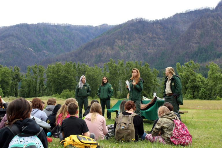 Washougal sixth graders from Canyon Creek Middle School listen to four U.S. Forest Service rangers talk about the Columbia River Gorge&#039;s post-fire recovery, at their &quot;Explore the Gorge&quot; outdoor school, hosted by Friends of the Columbia Gorge, and funded in part by a $5,000 Camas-Washougal Community Chest grant, on June 14. Forest Service rangers, pictured from left to right, are Angel Robinson, Sophie Steckler, Elisabeth Dare and Kat Schut.