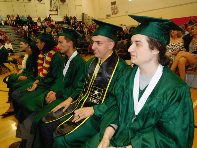 Hunter Harris (second from right), an enlistee in the U.S. Army, watches fellow Hayes Freedom graduates receive their diplomas Saturday, June 16, at Liberty Middle School. There were 33 graduating Renegades in the Class of 2018.