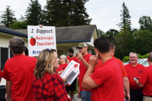 Members of the Washougal Association of Educators hold signs in support of Washougal teachers outside of the district office before the June 12 board of directors meeting. The board meeting was held the day after the school district proposed a salary schedule that would decrease new teacher's salary and give others a 1-percent raise, according to the teachers' union.