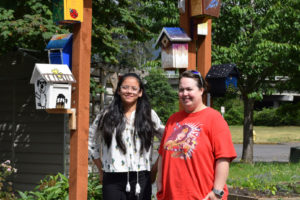 Jemtegaard Middle School eighth grader Annabella Arriola and Jemtegaard art teacher Dani Allen pose next to the birdhouses painted by Arriola and nine other classmates during Club 8, an afterschool program.