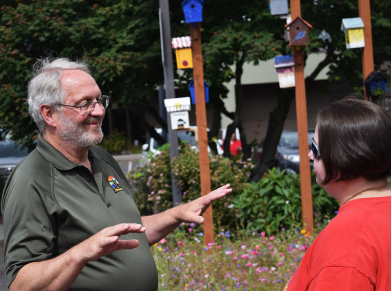 Washougal Councilman Paul Greenlee chats with Dani Allen, Jemtegaard Middle School art teacher, during an artists reception for the 11 middle school students who created designs on birdhouses hung outside Washougal city hall, Saturday, June 23.