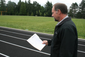 Washougal School District facilities manager Joe Steinbrenner shows a soils analysis document. It shows that the district imported 18 inches of engineered topsoil to install at the new football field at Jemtegaard Middle School in Washougal. Steinbrenner says debris found on the new field is from this topsoil, not from the demolished middle school, which lies underneath the field's eastern edges. (Photos by Wayne Havrelly/Post-Record)