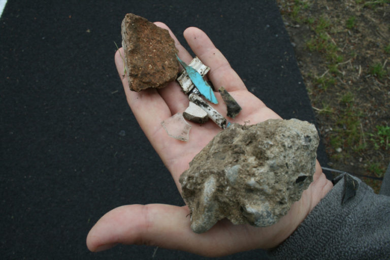 Pieces of concrete, plastic and one piece of glass.  Washougal eighth grade science teacher Brett Cox shows what he picked up on the new football field after school administrators told him the field was clear.