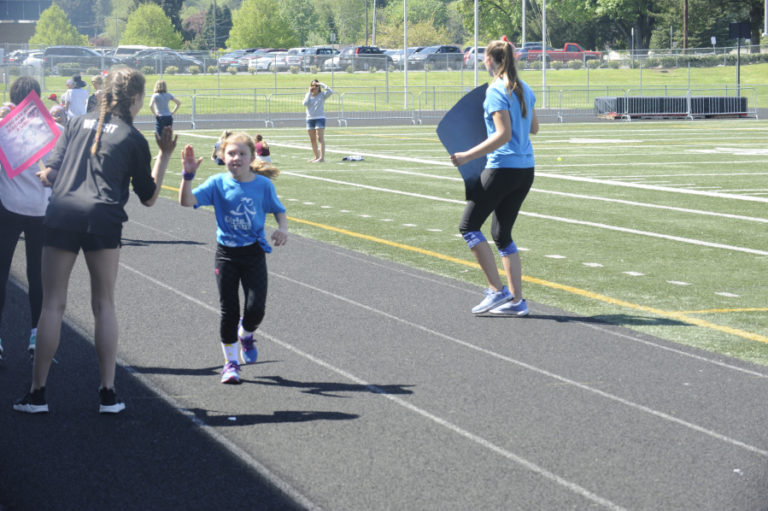 Liberty Middle School students give high fives to Helen Baller Elementary students participating in the Girls on the Run program, in Camas.