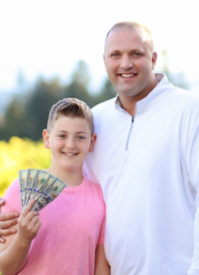 Ty Barnes, 12, and father Brody Barnes,38, pose with Ty&#039;s $500 prize for going a year without eating sugar. Ty and Brody have since started a new challenge together--they both will go one year without eating sugar and junk food.