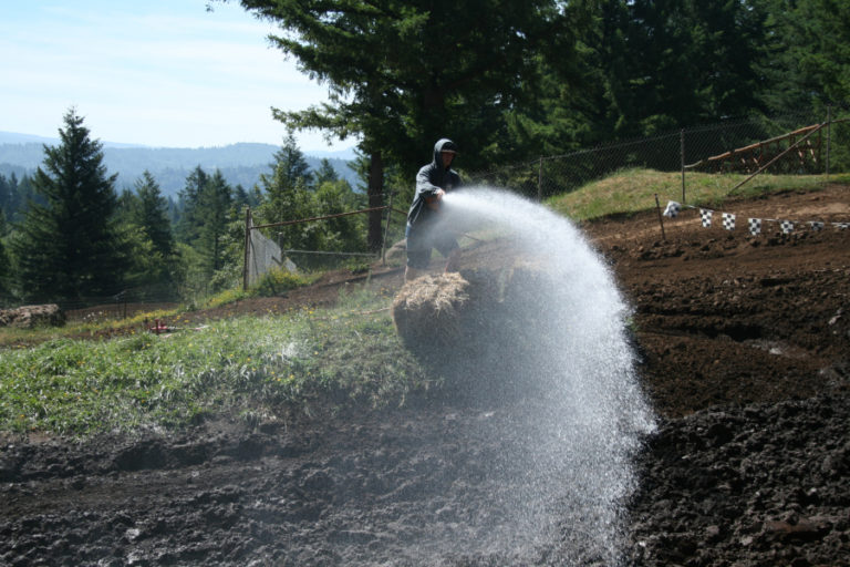 A track employee hoses down one of the turns at  Washougal Motocross Park.