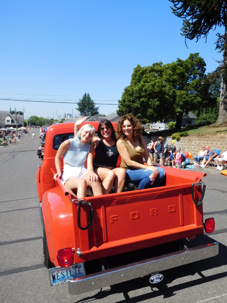 Dawn Stanchfield (center), the Camas-Washougal Chamber of Commerce 2018 “Business Person of the Year,” enjoys participating in the Camas Days Grand Parade, Saturday, July 28.  Stanchfield, owner of Lily Atelier, in downtown Camas for 15 years, has provided clothing for fashion shows that benefitted CDM Caregiving Services and Second Step Housing.    


