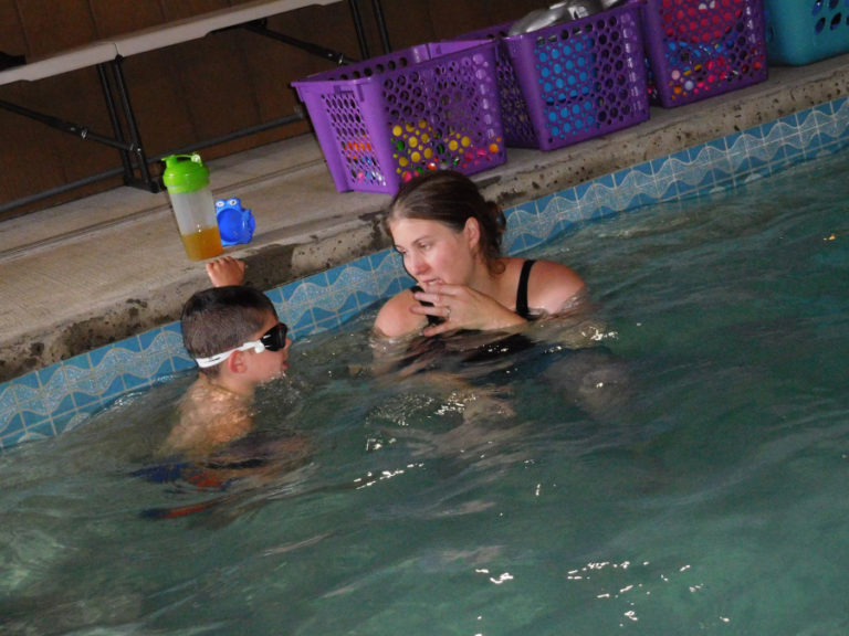 Kathi Sjostrom, owner of Just Add Water Swim School, in Camas, talks with Dane Hutton, 6, of Washougal, during a swimming lesson at an indoor pool at Sjostrom&#039;s home-based business.