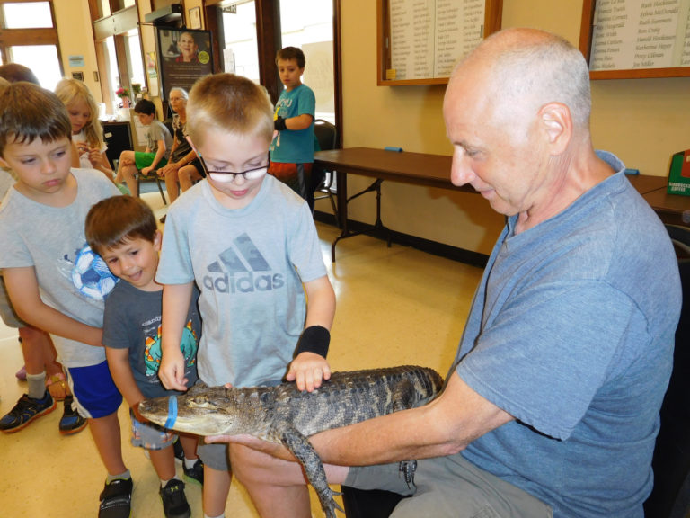 Children marvel at &quot;Daisy,&quot; an American alligator held by Steve Lattanzi with Steve&#039;s Creature Feature, on Aug. 8, in the Washougal Community Center.