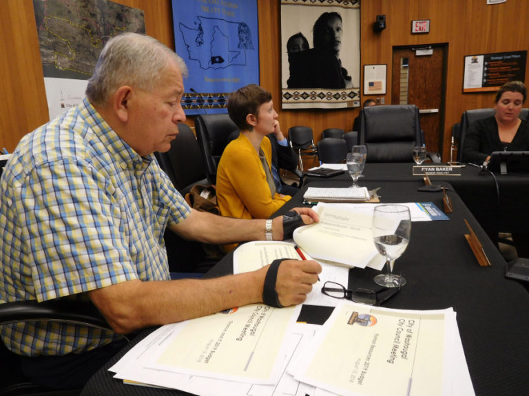 Washougal City Council members Ernie Suggs (left) and Alex Yost (right) listen to Finance Director Jennifer Forsberg (not pictured) talk about potential priorities of a preliminary 2019 Washougal budget during the Aug.