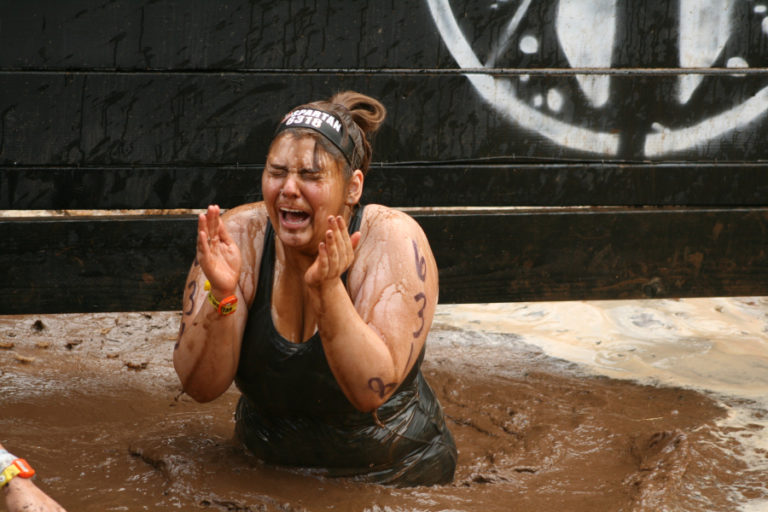 Kasey Admire from La Grande, Oregon tries to open her eyes after plunging into the mud.