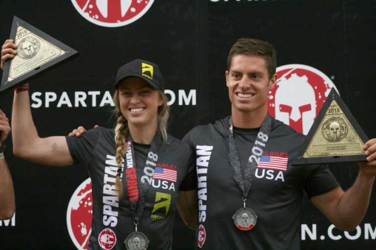 Elite Spartan winners Alyssa Hawley from Spokane and Greyson Kilgore of Salem, Oregon show off their trophies on the podium.