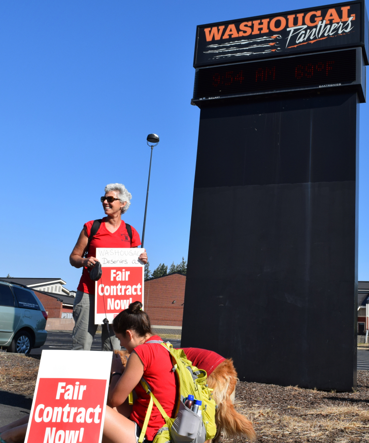A Washougal teacher holds a &quot;fair contract now&quot; sign outside the Washougal High School on Tuesday, Aug. 28, the first day of the Washougal teachers strike.