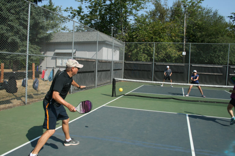 Two doubles teams volley during a pickleball game on Washougal&#039;s Hathaway Park Pickleball Courts.