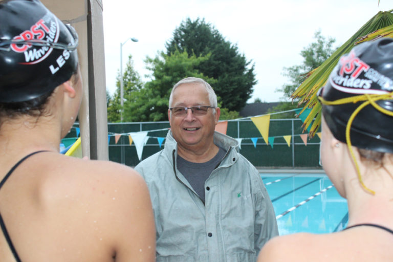 Left: Coach Mike Bemis laughs with swimmers from the Camas High School girls swim team during an early morning practice Aug. 24.  Look for previews of all Camas-Washougal fall sports teams in the Thursday, Sept.