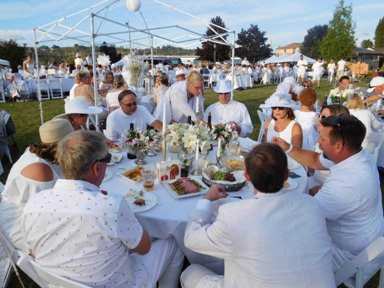 (Dawn Feldhaus/Post-Record)
Judy Musa (center), business development officer with the Fort Vancouver Regional Library Foundation, visits with attendees of the Dinner in White on the Columbia, Saturday, Sept. 8. Diners were encouraged to wear white clothing and decorate their tables in that same color tone, following in the tradition of the “Diner en Blanc” that started in Paris 30 years ago.