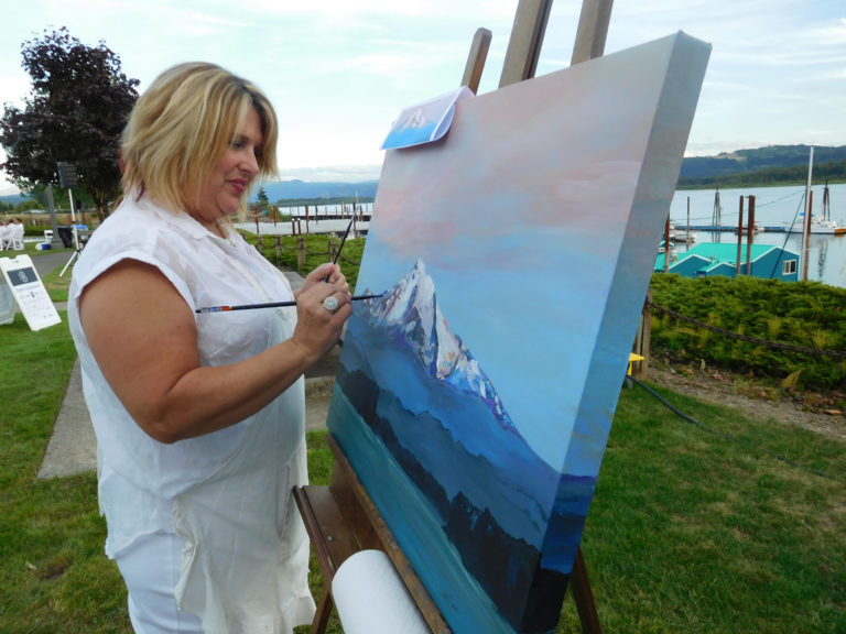 (Dawn Feldhaus/Post-Record)
Tamra Sheline, of Camas, paints an image of Mount Hood during a sunrise, at the Dinner in White on the Columbia, Saturday, Sept. 8, at Marina Park, in Washougal. Her painting was auctioned during the event, a fundraiser for the Washougal Library Building Fund.