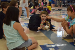 UPWARD mentor Katie Stallbaumer works with  students during camp to create a game using randomly selected items. The camp has two middle school teachers and a number of current or past Camas students to help organize daily activities.