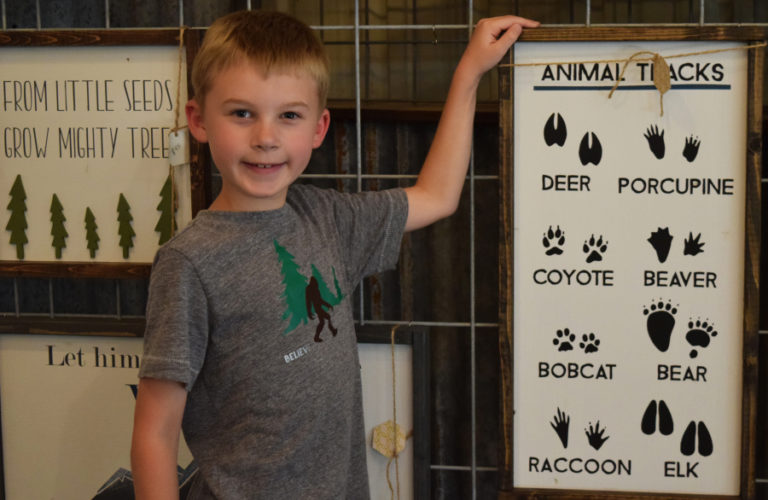 Bennett Christensen shows off his favorite sign at his family&#039;s Washougal farmhouse-based business, Honey BE Designs.