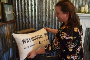 Honey BE Designs creator Kendra Christensen fluffs a hand-sewn pillow made from Pendleton wool in her Washougal farmhouse shop. 