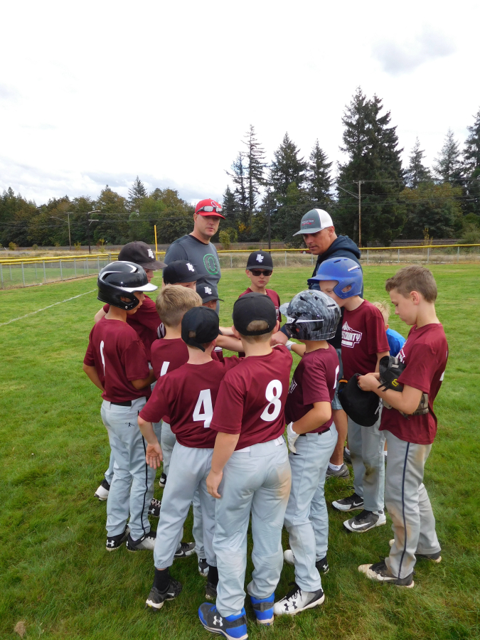 Coaches Dan Gibbons and Matt Neumann talk to their team, the East County Little League Squirrels, of Washougal, after a game Saturday, Sept. 15, at Schmid Field #2, in Washougal.
