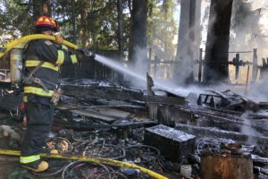 A Camas-Washougal Fire Department firefighter puts out a fire at an outbuilding in Washougal on Friday, Sept. 14. (Photo courtesy of the Camas-Washougal Fire Department)
