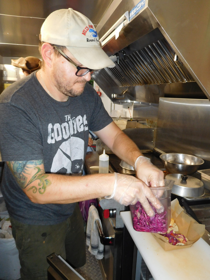 Jess Herndon, owner of Coast to Coast Fresh Eats &amp; Catering, prepares fish tacos Sept. 15, during Washougal&#039;s &quot;Pirates in the Plaza&quot; event. Herndon also brought his Coast to Coast food truck to the Oktoberfest celebration in Washougal, Sept. 28 and 29.