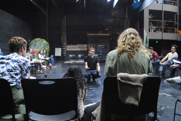 Director Sean Kelly (sitting, center) provides notes during a Sept.