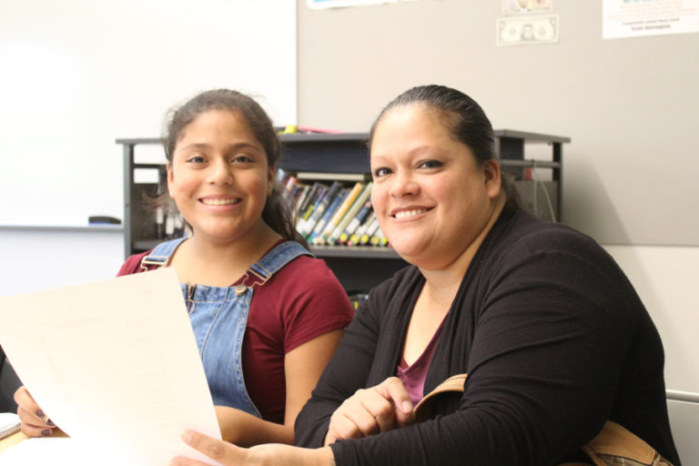 Amanda Aguilar (right) attends school on Oct. 11, with her daughter, Alisha Vargas, 11. Here, Aguilar works with her daughter in Scott Hoisington&#039;s sixth-grade world history class.