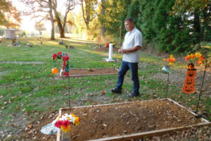 Clark County Cemetery District No. 1 Commissioner William Zalpys walks past natural burial sites at the Fern Prairie Cemetery. He said it takes one to two years for the graves, framed by untreated wood, to settle into the ground. 